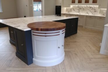 Bespoke in-frame kitchen with curved features including island with semi-circle wooden block