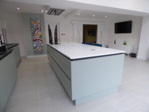 Burbidge Otto doors in Matt Porcelain colour with Anthracite Rail system. Kitchen Island houses a Neff induction hob with an Elica Extractor above.